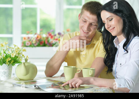 Portrait of happy young couple reading interesting book Stock Photo