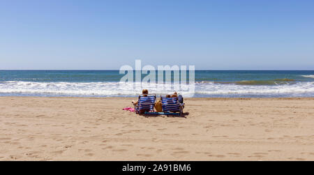 Couple on beach at Dunas de Artola, also known as Dunas de Cabopino.  The dunas, or dunes, are designated as a Natural Monument and are protected.  At Stock Photo