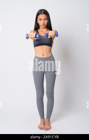 Full body shot of young Asian woman exercising with dumbbells and ready for gym Stock Photo
