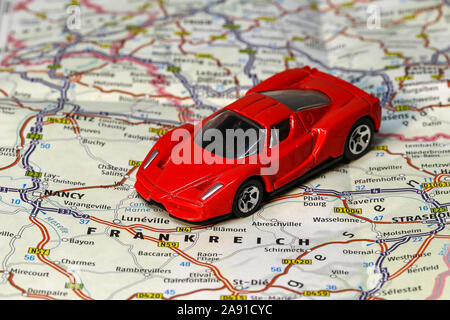Planning a car trip to France. Toy car is on a country map. Stock Photo
