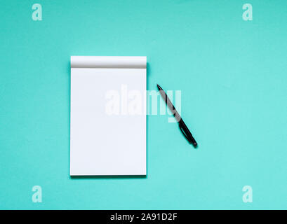 Top view workspace mockup on aqua background with open notebook and pen Stock Photo