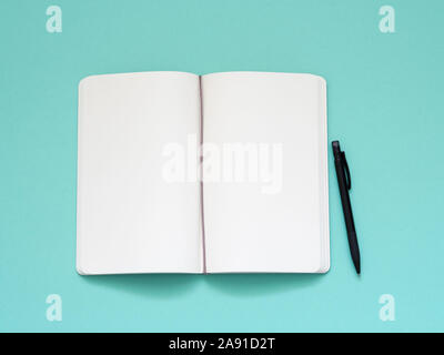 Top view of blank note paper with pen on aqua table background. Stock Photo