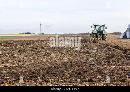 Wheel tractor with multi-plow, plowing the field. Plowing the land in late autumn. Podlasie, Poland. Stock Photo