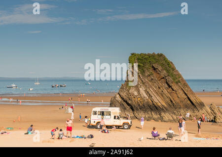 Ice cream van parked in front of Goskar Rock on Tenby's North Beach Stock Photo