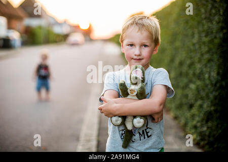 Boy holding stuffed dinosaur Stock Photo