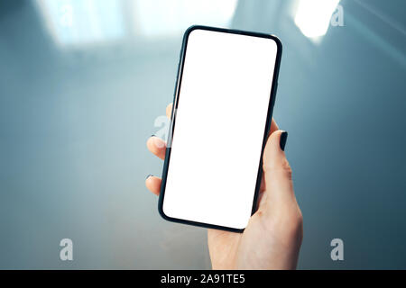 Woman using smartphone at modern office and bokeh blurred background. Blank screen for graphics display montage your advertising text message or promo Stock Photo