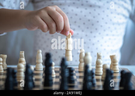a asia girl learn how to play chess game Stock Photo