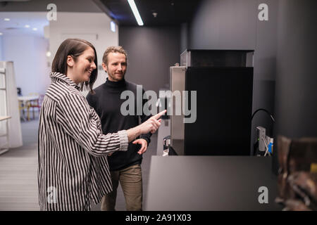 Smiling colleagues preparing coffee Stock Photo