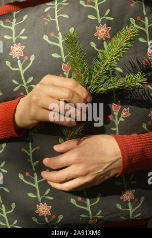 Woman is holding pine tree branch and pillow Stock Photo