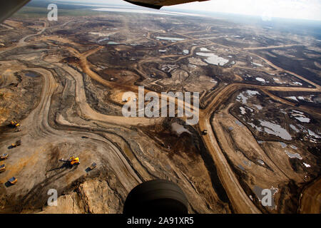 Excavation of oil sand at one of the oil sand mines in Fort McMurray in Alberta, Canada. The Athabasca oil sands deposit is among the largest in the world.  The bitumen, also commonly named tar (hence tar sands), contains lots of hydrocarbons, but is notoriously hard to extract. For every 100 BTU of energy extracted, 70 BTU is lost in the process. In 2011 alone, the oil sands operations in Canada produced 55 million tons of ‘greenhouse gas emissions’. That’s eight percent of Canada’s total emissions. Stock Photo