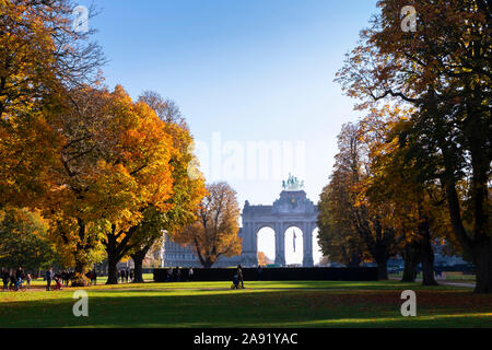 BRUSSELS, BELGIUM, November 10 2019: Sunny autumn morning in Cinquantenaire park with the Triumphal Arch in view and people strolling on alleys. Stock Photo