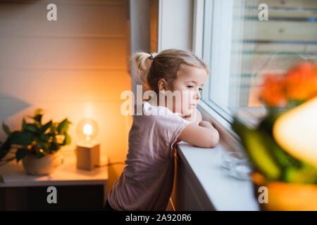 Girl looking through window Stock Photo