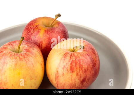 Plate of three whole ripe raw yellow and red apples Stock Photo