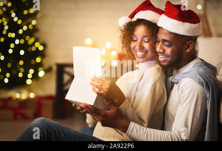 Xmas magic. Cute couple opening Christmas gift box Stock Photo