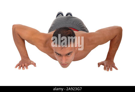 A young east Indian man doing his push aps on the floor in the studio isolated for white background Stock Photo