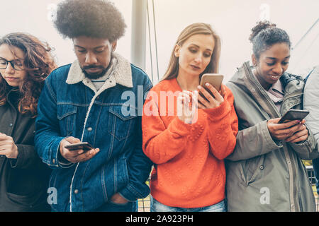 People choosing their phones over personal interaction Stock Photo