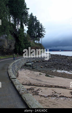 Winding path with walkers along Third Beach in Stanley Park, Vancouver, British Columbia, Canada, 2013 Winter Rain Stock Photo