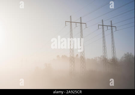 Electricity pylons in fog Stock Photo