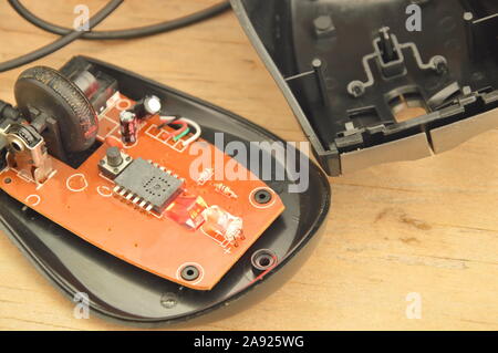 computer mouse separated parts with red light on wooden board Stock Photo