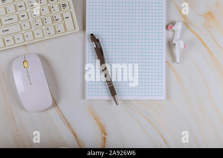 Workplace with notepad, wireless headphones and computer keyboard on mouse in marble background Stock Photo