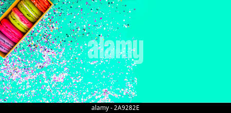colourful assorted french macaroons. Biscuits crumbled on trend color mint background. Festive banner Stock Photo