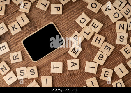 an empty chalkboard and cube alphabets on a wooden surface Stock Photo