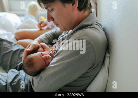 Father with baby in bed Stock Photo