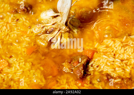 Cooking tasty pilaf. Rice added to Zirvak in a cauldron. Traditional pilaf cooking Stock Photo