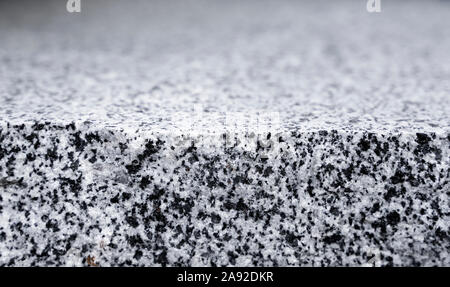 Natural stone grey granite background. Bright hard grey granite rock texture. Grey granite stone background. Grey granite untreated surface. Stock Photo