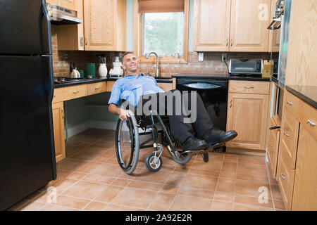 Mature man sitting in a wheelchair and smiling Stock Photo