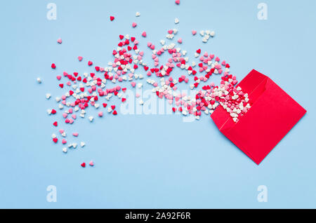 Opened red envelope and many felt hearts on blue background with place for text. Love letter mail correspondence relationship. Valentines day concept. Stock Photo