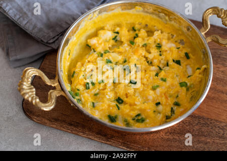 Scrambled eggs with cheese and spring onion. Breakfast is served. Stock Photo
