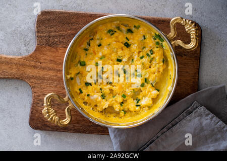 Scrambled eggs with cheese and spring onion. Breakfast is served. Stock Photo