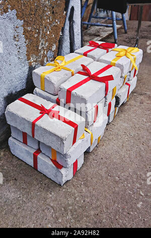 Heap of white bricks with red and yellow ribbon as gift to Christmas or birthday, top view. Christmas zero waste conccept Stock Photo