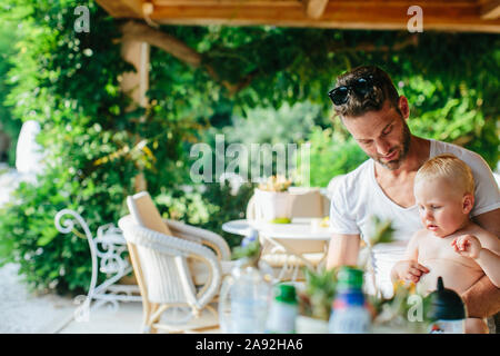 Father with toddler son in outdoor cafe Stock Photo