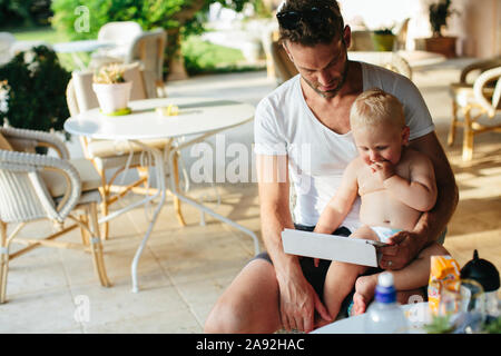 Father with toddler son in outdoor cafe Stock Photo