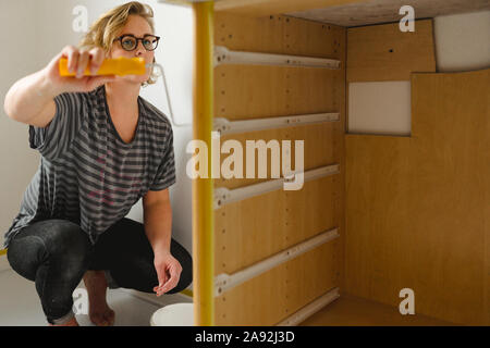 Woman painting cupboard Stock Photo