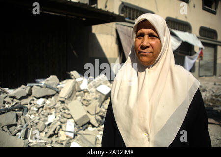 Tel Aviv, Palestinian Territories. 12th Nov, 2019. The neighbour Laila Jendeya stands in front of the house of the Islamic Jihad leader Baha Abu Al Ata, which was damaged after an Israeli air raid. Israel's security forces have taken targeted action to kill the military chief of Islamic Jihad in the Gaza Strip. Israel declared that it would not return to a policy of targeted killing. According to the army, this had been a unique action to avert 'a direct threat'. Credit: Saud Abu Ramadan/dpa/Alamy Live News Stock Photo