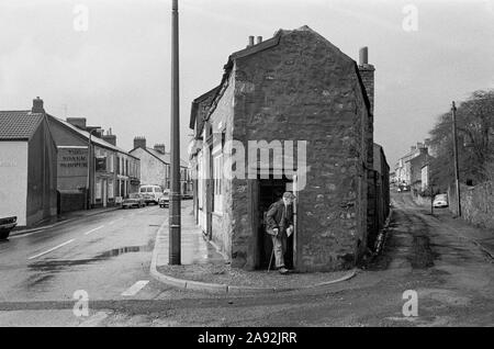 Man leaving a corner shop, Dowlais, Merthyr Tydfil, Mid Glamorgan, South Wales, 1983 Stock Photo