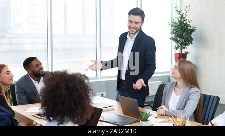 Businessman giving presentation to colleagues at meeting Stock Photo