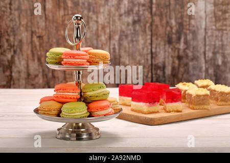 Macaroons cookies any types of colour on metal stand and empty space for text Stock Photo
