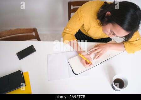 Woman writing in diary Stock Photo