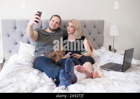 Couple on bed taking selfie Stock Photo