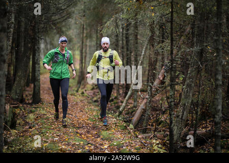 Man and woman running in forest Stock Photo