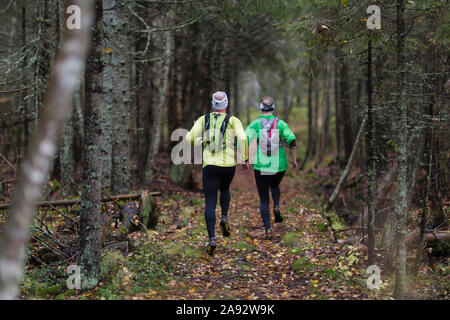 Man and woman running in forest Stock Photo