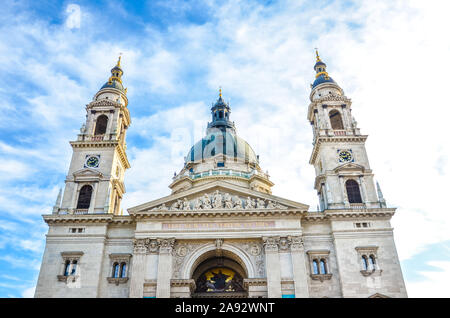 Front facade of St. Stephen's Basilica in Budapest, Hungary on with blue sky and clouds above. Roman Catholic basilica built in neoclassical style. Two towers and cupola of the religious building. Stock Photo