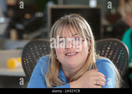 Young woman with Down Syndrome working in an office Stock Photo