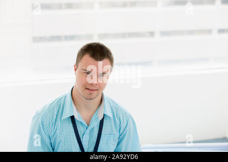 Young man with Down Syndrome working as a hospital aid Stock Photo