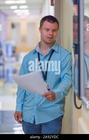 Young man with Down Syndrome doing paperwork in a hospital Stock Photo