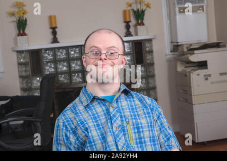 Man with Down Syndrome working in an office Stock Photo